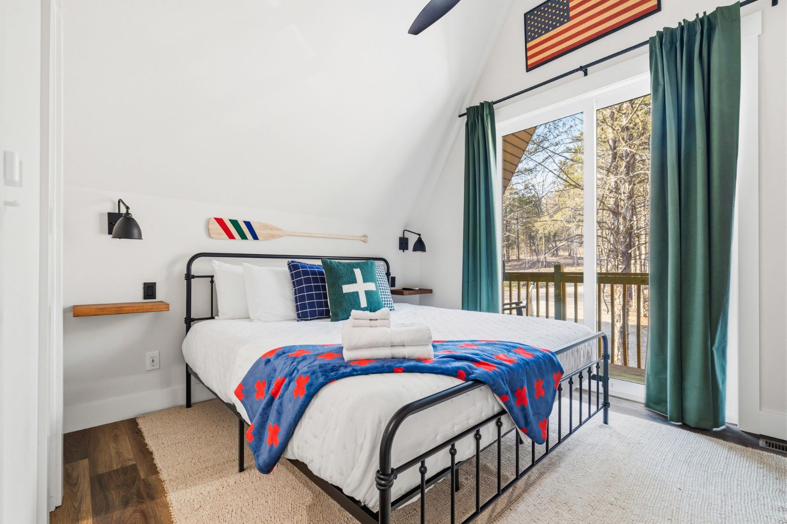 King bedroom with rustic iron bed and oar wall accent