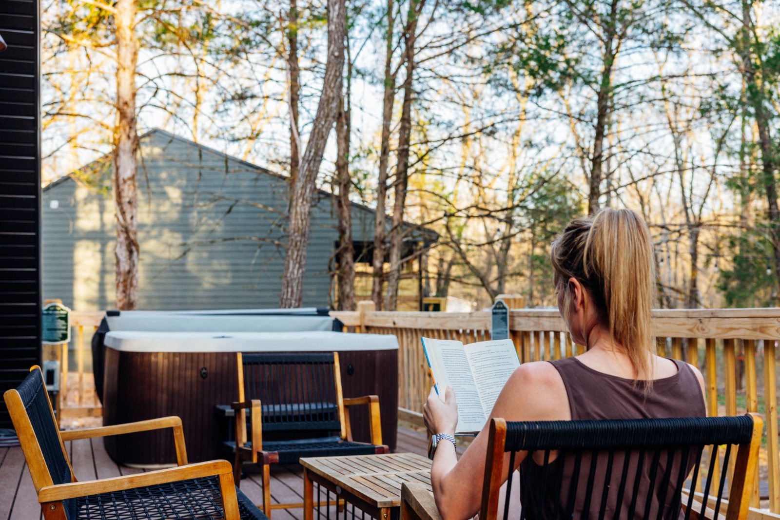 A guest reading on the deck near the hot tub at golden hour