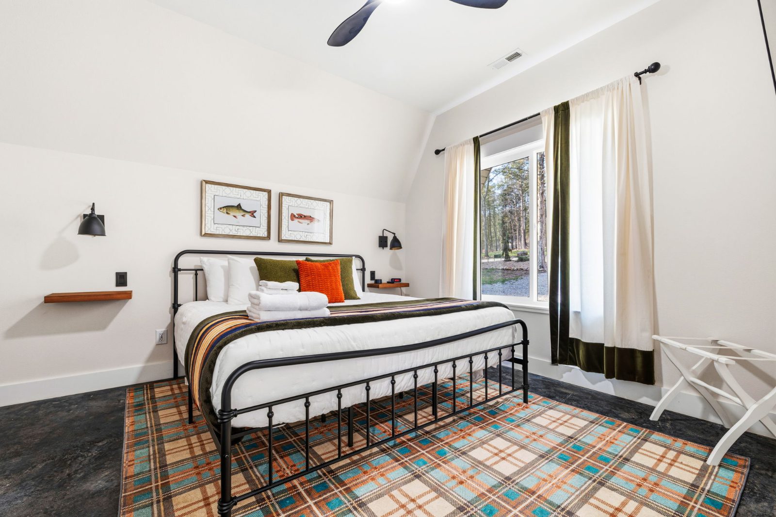 Second king bedroom with fishing prints and forest view